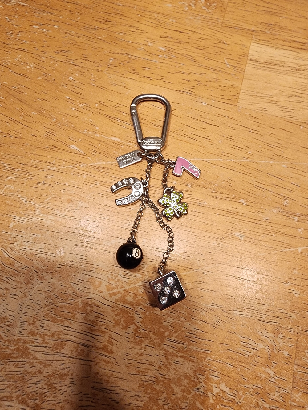 silver-tone Coach Lucky Charm Keychain featuring a mix of gambling and good luck